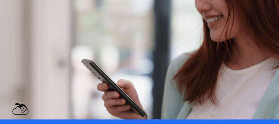 Paciente sorrindo enquanto utiliza o celular, representando o atendimento via WhatsApp para clínicas e consultórios de saúde.