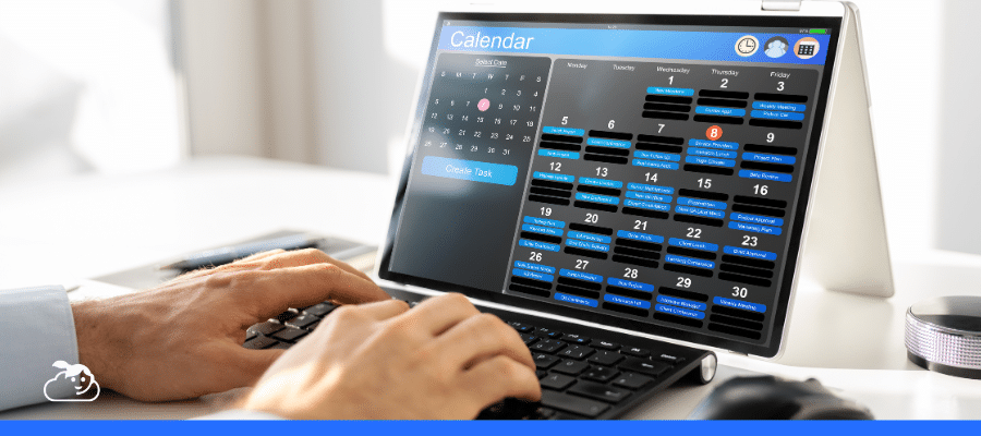 Close das mãos de uma pessoa digitando em um laptop que exibe uma interface de calendário digital repleta de compromissos. A imagem ilustra a organização e agilidade proporcionadas pelo atendimento automatizado na gestão de agendas.