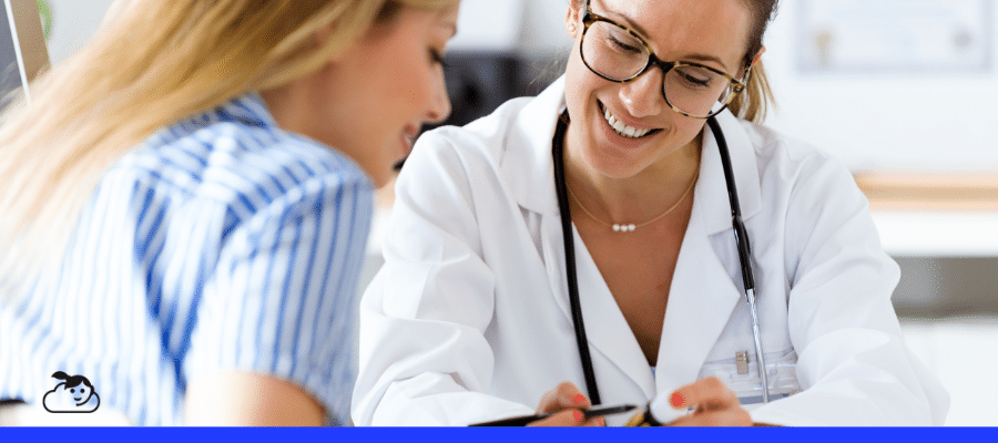 Médica sorridente e atenciosa explicando tratamento ou receita a uma paciente também sorridente em um consultório, focando na importância da comunicação para fidelizar paciente.