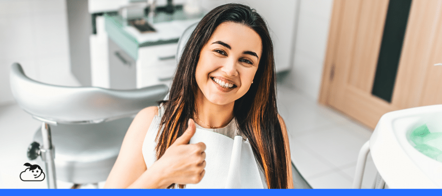 Paciente sorrindo em consultório odontológico após atendimento, representando como encantar pacientes por meio de uma experiência positiva e acolhedora na clínica.