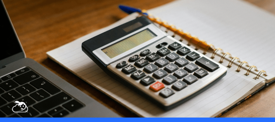 Calculadora financeira sobre um caderno aberto ao lado de um laptop, ilustrando a organização do imposto de renda para dentistas em um ambiente de escritório.