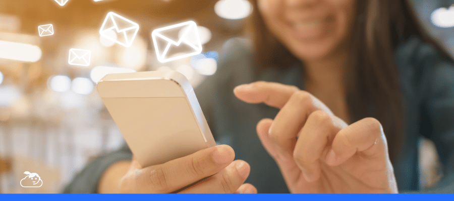 Pessoa usando um smartphone com ícones de envelopes (e-mail ou mensagem) flutuando, representando a comunicação digital instantânea e a aplicação de marketing conversacional.