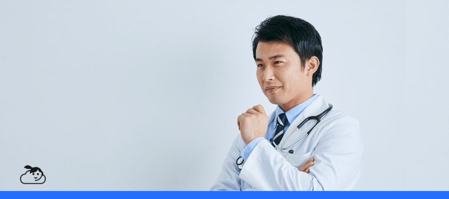 Médico de jaleco branco e estetoscópio no pescoço olha pensativo para o lado, representando a tomada de decisão e o uso ético da inteligência artificial na medicina. No canto inferior esquerdo, aparece o logotipo de uma nuvem com um rosto sorridente sobre uma faixa azul.