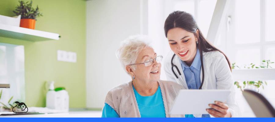 Profissional de saúde e paciente idosa compartilham um momento de atenção e cuidado em um ambiente iluminado, reforçando uma experiência do paciente na saúde positiva e acolhedora.