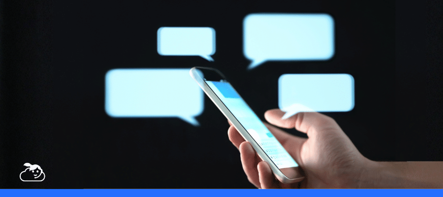 Celular com balões de conversa digitais representando o uso de chatbot com Inteligência Artificial em clínicas para atendimento de pacientes.